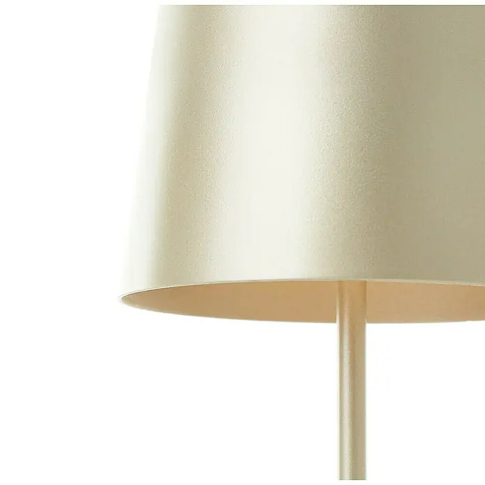 Brilliant Akku-Tischleuchte Kaami - 2 W, Gold, Warmweiß - Nahaufnahme eines Lampenschirms in einer warmen, cremefarbenen Tönung, der sanftes Licht ausstrahlt. Die schlichte Eleganz betont die minimalistische Ästhetik.