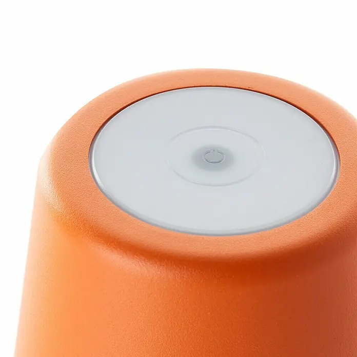 Brilliant Akku-Tischleuchte Kaami - 2 W, Orange, Warmweiß - Nahaufnahme einer orangefarbenen Tischleuchte mit einem runden, weißen Lichtknopf oben.