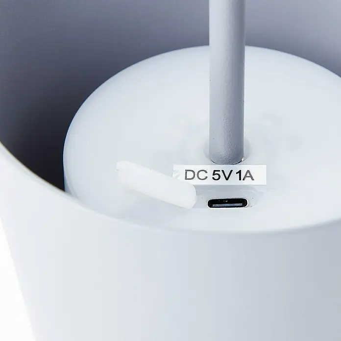 Brilliant Akku-Tischleuchte Kaami - 2 W, Grau, Warmweiß - Nahaufnahme eines weißen Geräts mit einem USB-C-Anschluss und einem Aufkleber mit der Aufschrift "DC 5V 1A".