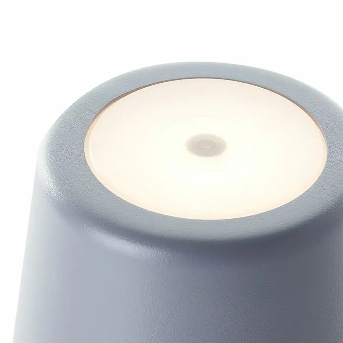 Brilliant Akku-Tischleuchte Kaami - 2 W, Grau, Warmweiß - Nahaufnahme einer grauen LED-Tischleuchte mit eingeschaltetem Licht, die eine stimmungsvolle Atmosphäre schafft.