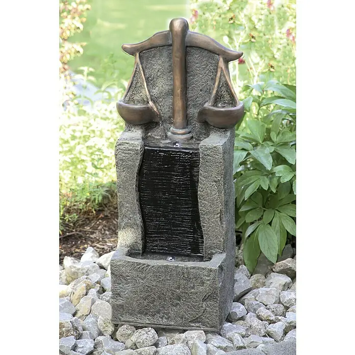 Silex Gartenbrunnen Waage - 35 cm x 26 mm x 81 cm, Kunststoff - Das Foto zeigt einen dekorativen Justicia-Brunnen mit Waage, der Wasser fließt und auf einem Kiesbett steht.