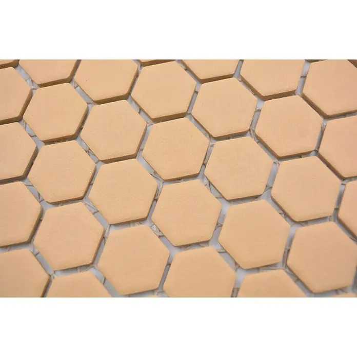 Mosaikfliese Hexagon Uni HX AT27 - 26 x 30 cm, Orange, Matt - Ein Muster aus sechseckigen Fliesen in einem sanften Beigeton, ideal für moderne und klassische Innenräume. Die Textur sorgt für eine ansprechende Optik.