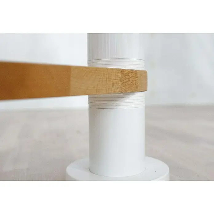 Dolle Spindeltreppe Oslo - Durchmesser: 140 cm, Weiß, Farbe Stufen: Buche Natur, Geschosshöhe: 252 cm - 276 cm - Nahaufnahme eines modernen weißen Tischbeins mit einer hölzernen Querstrebe, das schlichte Design und die klaren Linien des Möbelstücks betonend.