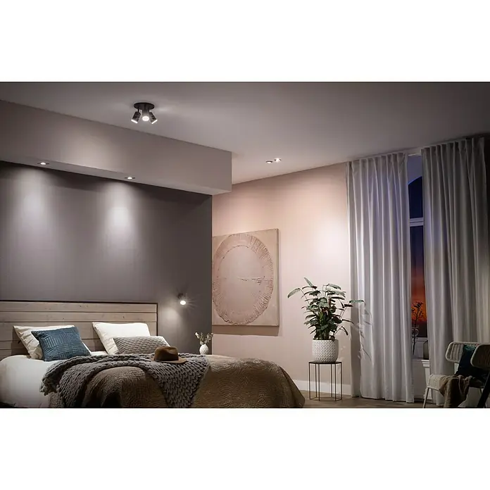 Philips Hue Bombilla LED inteligente - GU10, Intensidad regulable, Blanco cálido, 350 lm, 5,7 W - Una vista de habitación elegante con una moderna lámpara de techo que ilumina el espacio y crea un ambiente agradable.
