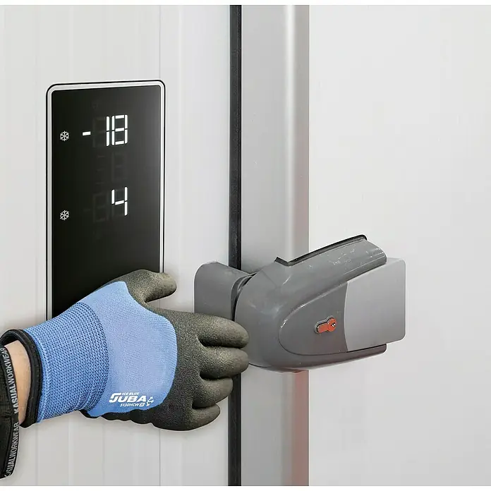 Juba Guantes de trabajo H5130 - Talla del guante: 10, Azul/Negro, 2 ud. - Una cámara frigorífica con una persona con un guante Juba abriendo la puerta con pantalla digital de temperatura.