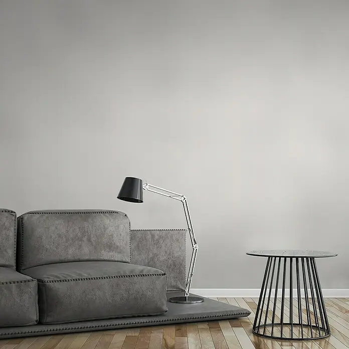 A.S. Création Flavour Vliestapete II - Creme, Uni, 10,05 x 0,53 m - Stylische Wohnzimmereinrichtung mit grauem Sofa, Stehlampe und Beistelltisch. Das moderne Designelement verleiht dem Raum Eleganz und Komfort.