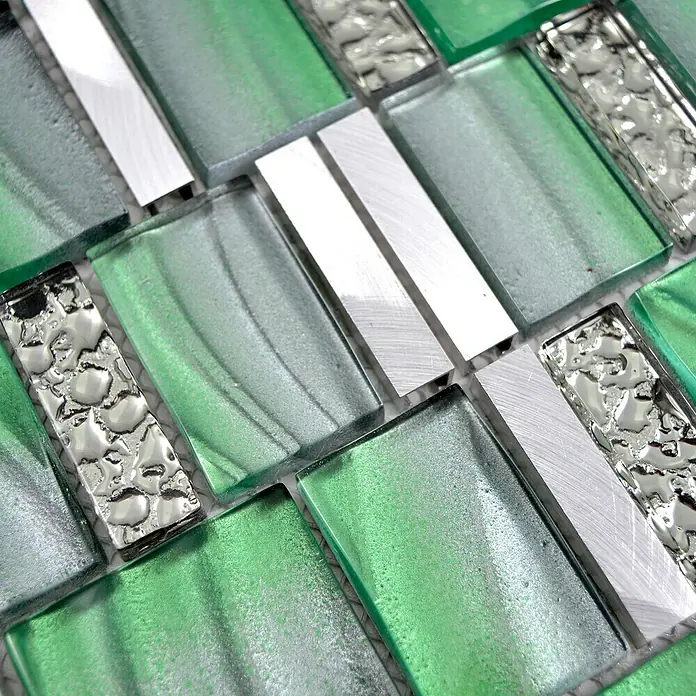 Mosaikfliese Crystal Mix XCM SUN07 - 29,7 x 29,5 cm, Grün, Glänzend - Nahaufnahme eines Mosaiks mit grünen Glas- und silbernen Metallelementen, das eine Textur und Reflexion zeigt.