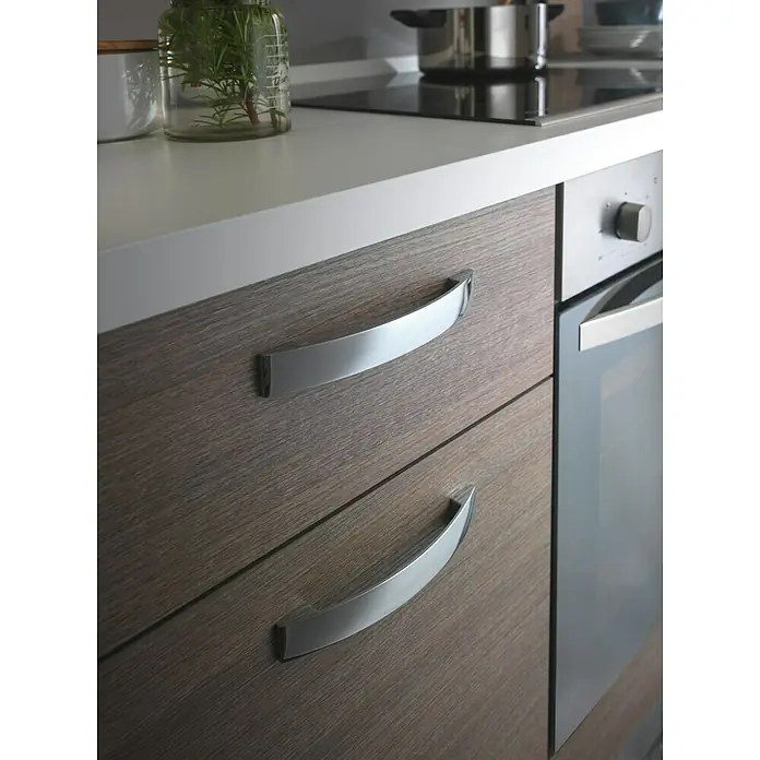 Marinelli Cucine Vormontierte Küchenzeile Rita - Breite: 270 cm, Eiche Grau, Mit Elektrogeräten - Nahaufnahme von modernen Küchenschränken mit eleganten, gebogenen Chromgriffen, die dem Holzdesign eine stilvolle Note verleihen.
