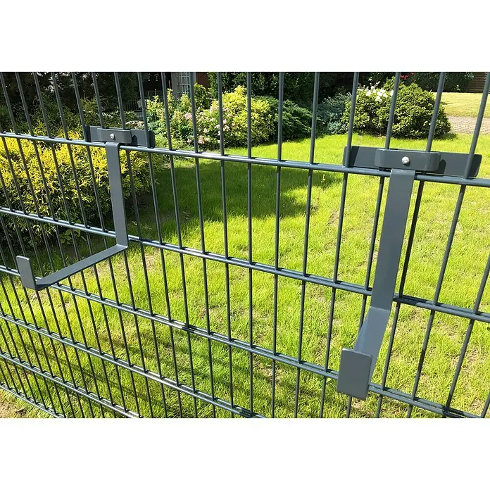 WMT Eindrehhalterung für Blumenkästen - 22 x 17 x 24 cm, Anthrazit - Ansicht eines Gartenzauns mit zwei daran befestigten grauen Metallhalterungen.