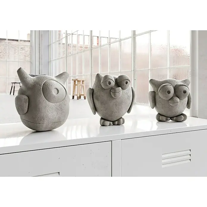 Ultrament Beton-Gießmasse Bastel Beton - Hellgrau, 1,5 kg - Drei dekorative Eulenfiguren aus Beton stehen auf einem weißen Sideboard vor einem Fenster.