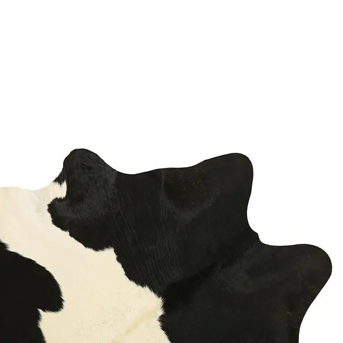 Esbeco Kuhfell - Schwarz/Weiß, 100 % Echtfell - Ausschnitt einer Kuhfell-Teppich mit einem Schwarz-Weiß-Muster, der eine natürliche und rustikale Atmosphäre vermittelt.