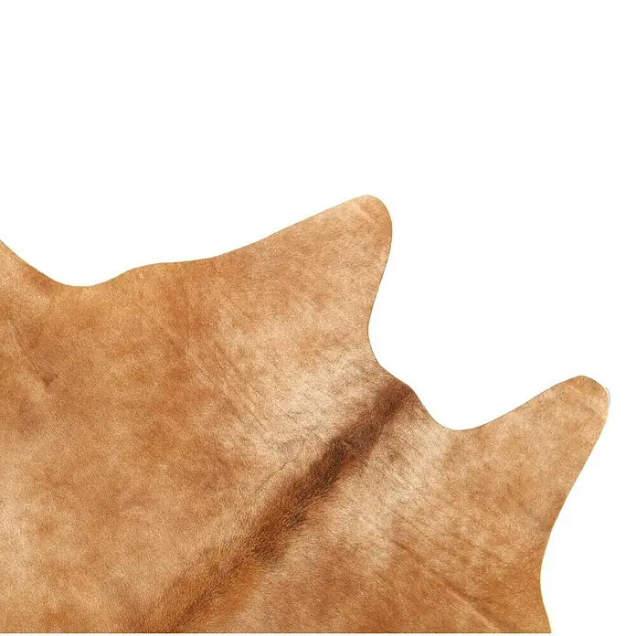 Esbeco Kuhfell - Exotisch Mittel, 100 % Echtfell - Detailansicht eines hellbraunen Kuhfells mit unregelmäßiger Form, ideal als Teppich oder Dekoration. Die Textur ist weich und natürlich.