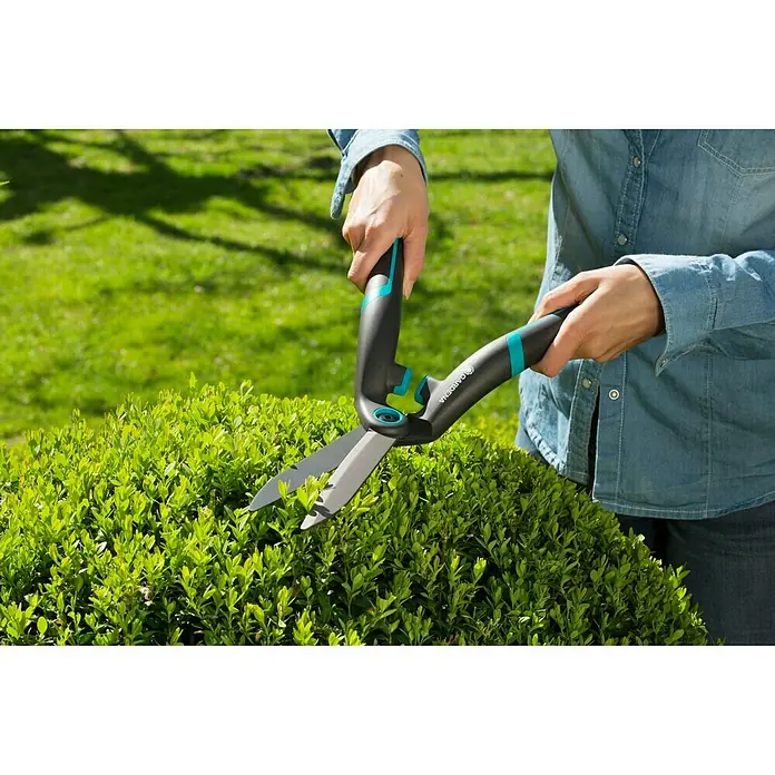 Gardena Hand-Heckenschere PrecisionCut - Länge: 475 mm - Nahaufnahme einer Person, die mit einer Gardena Strauchschere eine Hecke schneidet. Ideal für Gartenarbeiten.
