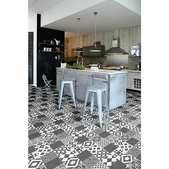 Beauflor PVC-Boden Meterware Plaza - 400 cm, Amadora, Schwarz/Blau - Kücheninsel mit zwei Barhockern auf einem auffälligen schwarz-weiß gemusterten Boden. Die Beleuchtung erfolgt über Hängelampen.