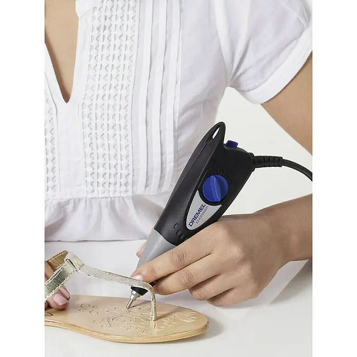 Dremel Graviergerät 290-3 Hobby - 35 W - Nahaufnahme einer Frau, die mit einem Dremel-Graviergerät ein Muster in einen Ledersandalen graviert.