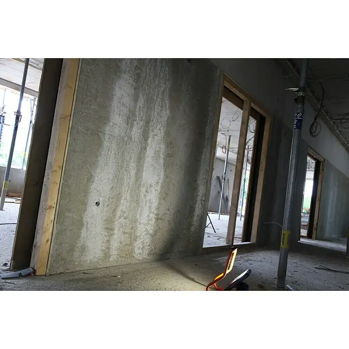 Ledvance LED-Strahler - 30 W, 2.700 lm, 4.000 K, L x B x H: 19 x 22 x 29 cm, IP44 - Innenaufnahme einer Baustelle mit Betonwänden, Holzelementen und Baustützen, beleuchtet durch eine Arbeitsleuchte.