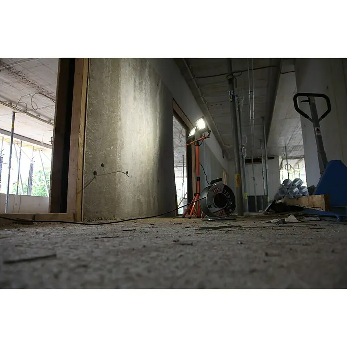 Ledvance LED-Arbeitsleuchte5.400 lm, Lichtfarbe: Kaltweiß, Anzahl Leuchtmittel: 2 Stk. - Baustellenbeleuchtung mit Kabeltrommel und Stativ im Rohbau. Die Lampe strahlt hell in den Raum.