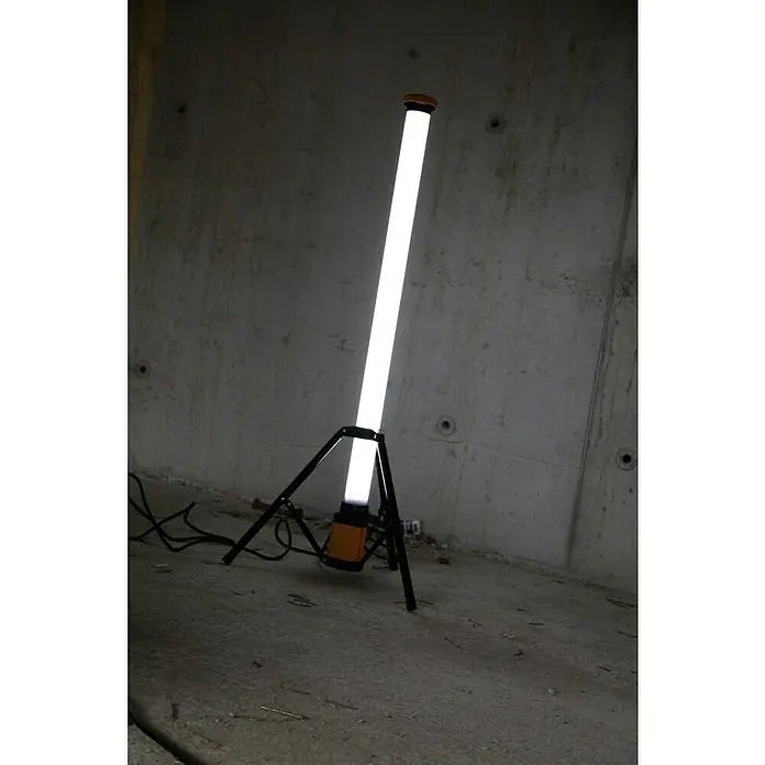 Profi Depot LED-Strahler L120 - 5.030 lm, 6.400 K, L x B x H: 74 x 85 x 158 cm, IP54 - Eine Stehlampe mit hellem Lichtstrahl steht in einem Raum mit Betonwand. Sie leuchtet den Raum taghell aus.