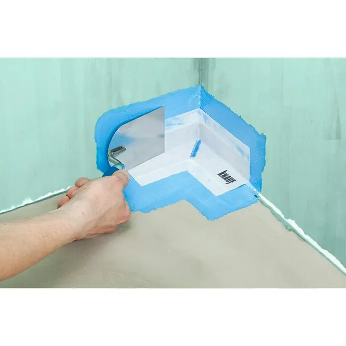 Knauf Dichtecke - Innenecke, 1 Stk. - Die Abbildung zeigt ein Eckdichtband von Knauf, das mit einer Spachtel an einer Wand befestigt wird, um Ecken abzudichten.