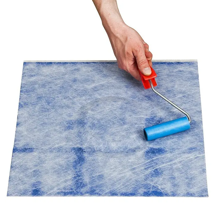 Knauf Butyl-Dichtmanschette - 1 Stk., 370 x 370 mm - Nahaufnahme eines Handrollers mit blauem Roller auf einer blauen Oberfläche, ideal zum Glätten oder Auftragen von Klebstoffen.
