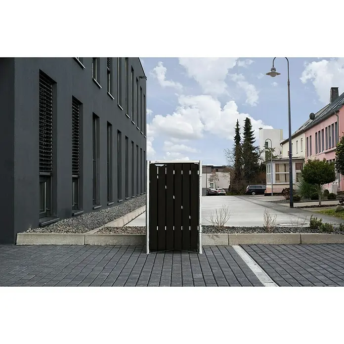 Hide Mülltonnenbox - 80,7 x 69,7 x 115,2 cm, Passend für: 1 Mülltonne 180 - 240 l, Kunststoff, Schwarz - Stilvolle Mülltonnenbox mit schwarzem Holz und silbernem Rahmen vor modernem Gebäude.