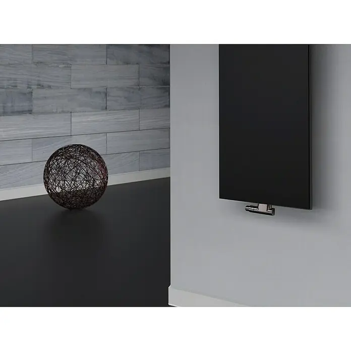 Szagato Designheizkörper Manhattan 2 - B x H: 470 x 1.200 mm, Wärmeleistung bei Vorlauftemperatur von 75 °C (D: 50): 799 W, Schwarz, Mit 1 Handtuchhalter (50 mm) - Elegante Nahaufnahme eines schwarzen Heizkörpers an einer grauen Wand, ergänzt durch moderne Deko-Elemente.