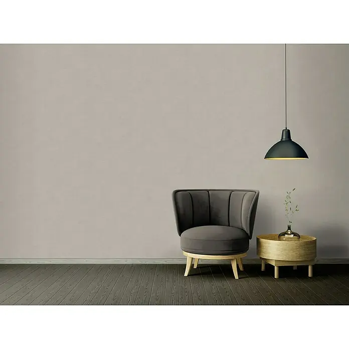 A.S. Création Ethnic Origin Vliestapete - Grau, Uni, 10,05 x 0,53 m - Elegantes Interieur mit einem grauen Sessel und einem runden Beistelltisch unter einer stilvollen Hängelampe, die eine warme Atmosphäre erzeugt.