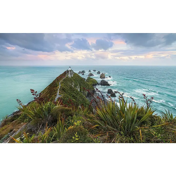 Komar Pure 2 Fototapete Stormy Sea - B x H: 400 x 250 cm, Vlies - Landschaft mit einem Leuchtturm auf einer Klippe, üppiger Vegetation und dem Ozean unter einem bewölkten Himmel, der eine malerische und ruhige Szene erzeugt.