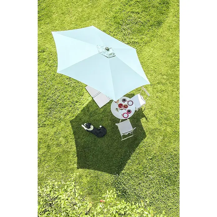 Suncomfort Marktschirm rund Pop Up - Sandweiß, Durchmesser Bespannung: 300 cm - Helle Rasenfläche mit einem hellblauen Sonnenschirm über einem Tisch mit Geschirr und einem ruhenden Hund.