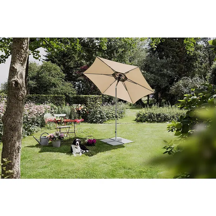 Suncomfort Marktschirm rund Pop Up - Sandweiß, Durchmesser Bespannung: 300 cm - Sonnenschirm spendet Schatten in einem gepflegten Garten. Der Schirm steht auf einer stabilen Basis neben einem entspannten Hund.