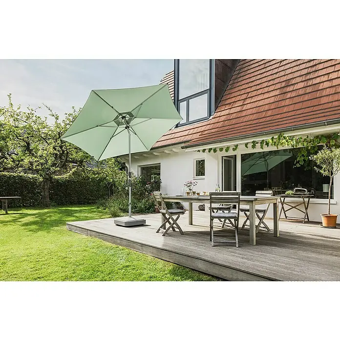 Suncomfort Marktschirm rund Slide - Steingrau, Durchmesser Bespannung: 250 cm - Ein quadratischer Sonnenschirm in Mintgrün steht auf einer Holzterrasse neben einem Esstisch und Stühlen. Perfekt für entspannte Stunden im Freien.