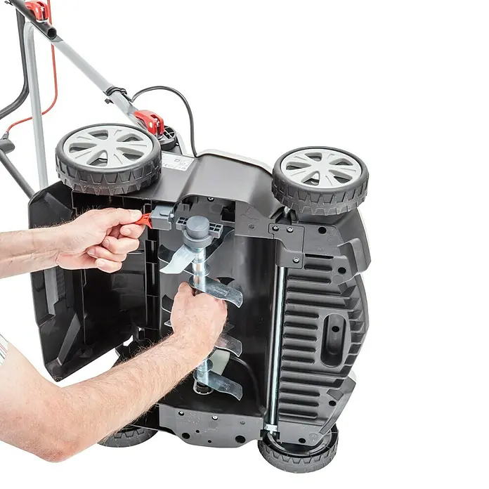 AL-KO Elektro-Vertikutierer Combi Care 36.8 E Plus Comfort - 1.400 W, Arbeitsbreite: 36 cm - Eine Nahaufnahme eines vertikalen Rasenlüfters mit bloßen Händen, der Messer und Einstellmechanismen für eine individuelle Rasenpflege anpasst.
