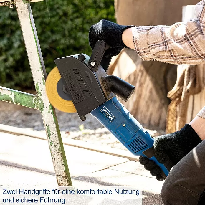 Scheppach Satiniermaschine MRS1300 - 1.300 W, 900 U/min - 3.200 U/min - Blaue Scheppach Elektro-Drahtbürste wird beidhändig zum Abbeizen eines Metallrahmens verwendet.