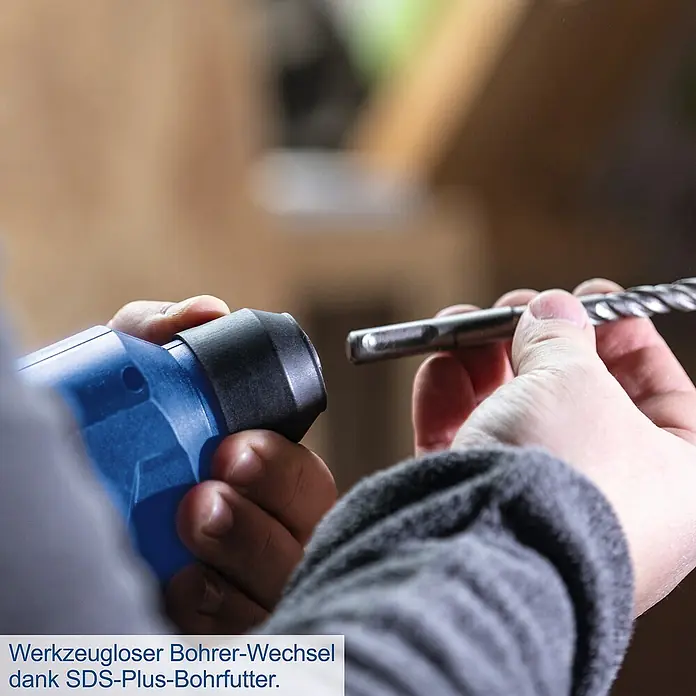 Scheppach IXES 20V Akku-Bohrhammer C-RHD130-X - 20 V, Ohne Akku, 1,3 J - Nahaufnahme einer Person, die einen SDS-Plus-Bohrer in eine Bohrmaschine einsetzt, was einen werkzeuglosen Bohrerwechsel dank des SDS-Plus-Bohrfutters ermöglicht.