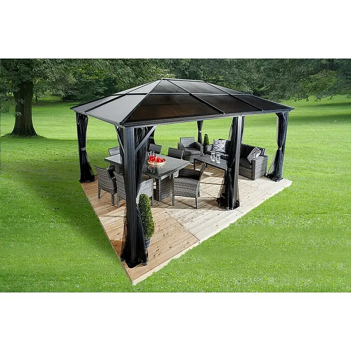 Sojag Standard-Pavillon Meridien 12 x 16 - B x T: 485 x 365 cm, Farbe Gestell: Anthrazit, Aluminium - Ein elegantes Gartenhaus mit einem Tisch und Stühlen, umgeben von üppigem Grün, bietet eine stilvolle Outdoor-Oase für Entspannung.