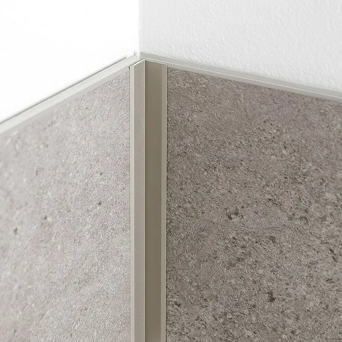 Grosfillex Wall+ Winkelleiste innen - 2.600 x 12 x 12 mm, Titan - Eckansicht von grauen Wandpaneelen, verbunden durch ein hellgraues Eckprofil, das einen sauberen Übergang zur weißen Decke schafft.