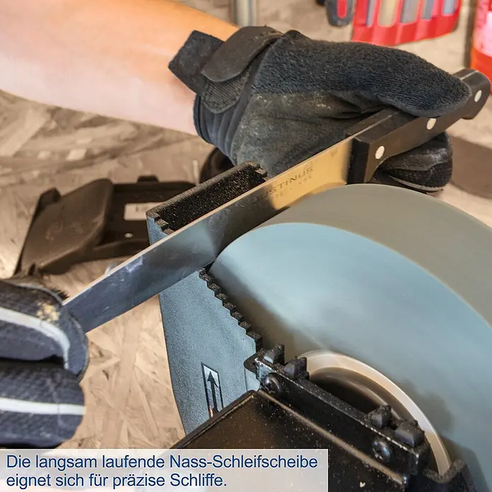 Scheppach Elektro-Nass-Trockenschleifer BG 200W - 250 W - Eine Person schärft ein Messer mit einer langsam laufenden Nass-Schleifscheibe für präzise Schliffe.