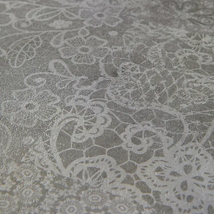 Grosfillex Wall+ Wandpaneel - Cement Flow, 900 x 450 x 5 mm - Nahaufnahme eines eleganten, grauen Untergrunds mit einem zarten, weißen Spitzenmuster, das für eine stilvolle Präsentation sorgt.
