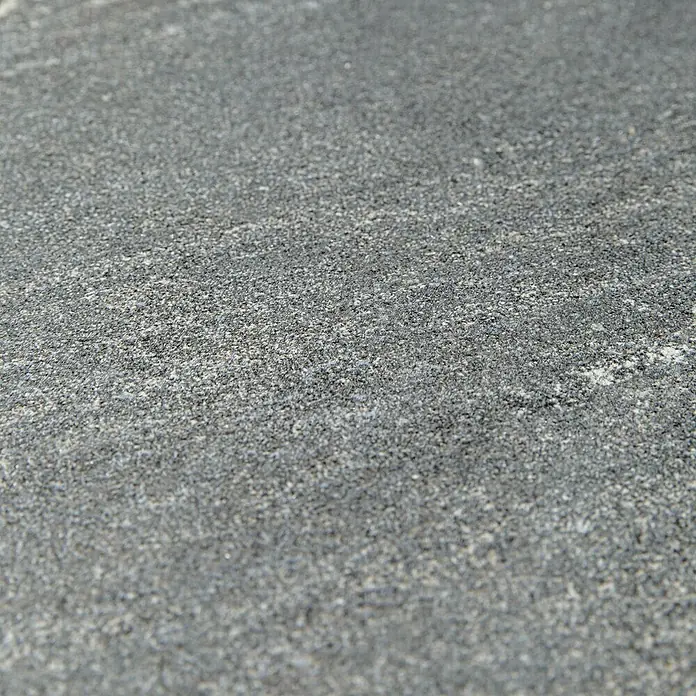 Grosfillex Wall+ Wandpaneel - 600 x 300 x 5 mm, Dark Stone, 11 Stk. - Nahaufnahme einer grauen, strukturierten Oberfläche, die an Stein oder Beton erinnert und eine interessante Textur für Hintergründe bietet.
