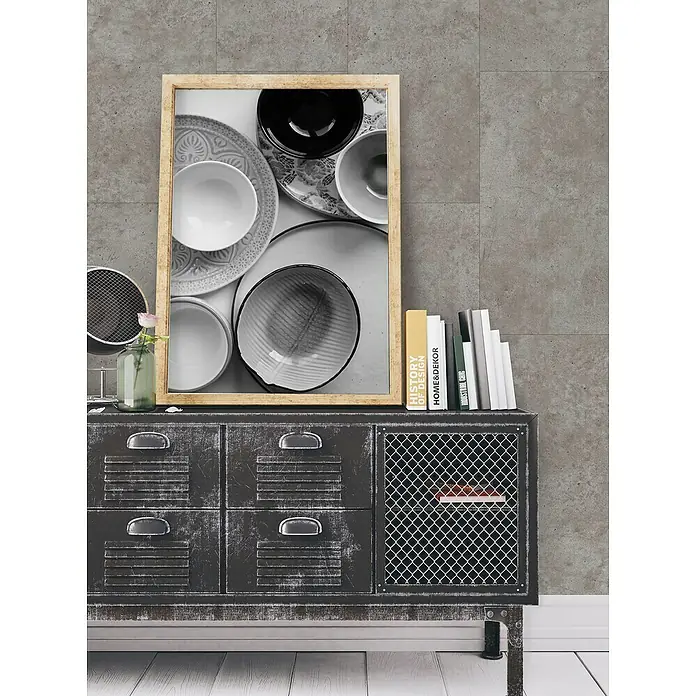 Grosfillex Wall+ Wandpaneel - Grey Concrete, 600 x 300 x 5 mm - Ein stilvolles Sideboard mit Schubladen und Drahtgeflecht-Tür, dekoriert mit einem gerahmten Bild und Büchern, verleiht dem Raum einen industriellen Charme.
