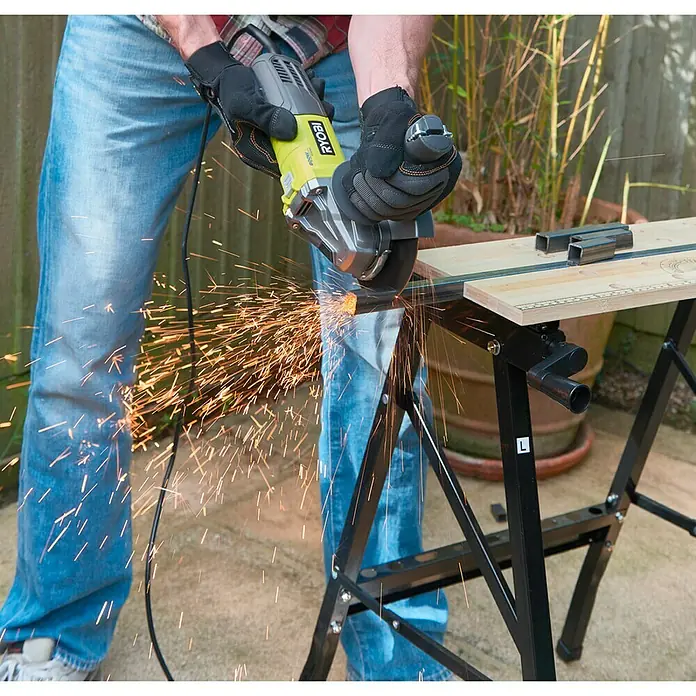 Ryobi Amoladora angular eléctrica RAG800-125G - 800 W, Diámetro disco: 125 mm, Número de revoluciones de marcha en vacío: 12.000 r.p.m. - Amoladora angular Ryobi en acción: Un artesano corta metal con chispas. El equipo de protección es esencial para la seguridad.