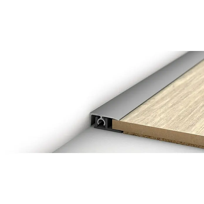 LOGOCLIC Abschlussprofil 313 - Silber, 0,9 m x 26 mm, Montageart: Stecken - Nahaufnahme eines Bodenprofils aus Aluminium, das an einer Wand befestigt ist und einen sauberen Übergang zum Holzboden bildet.
