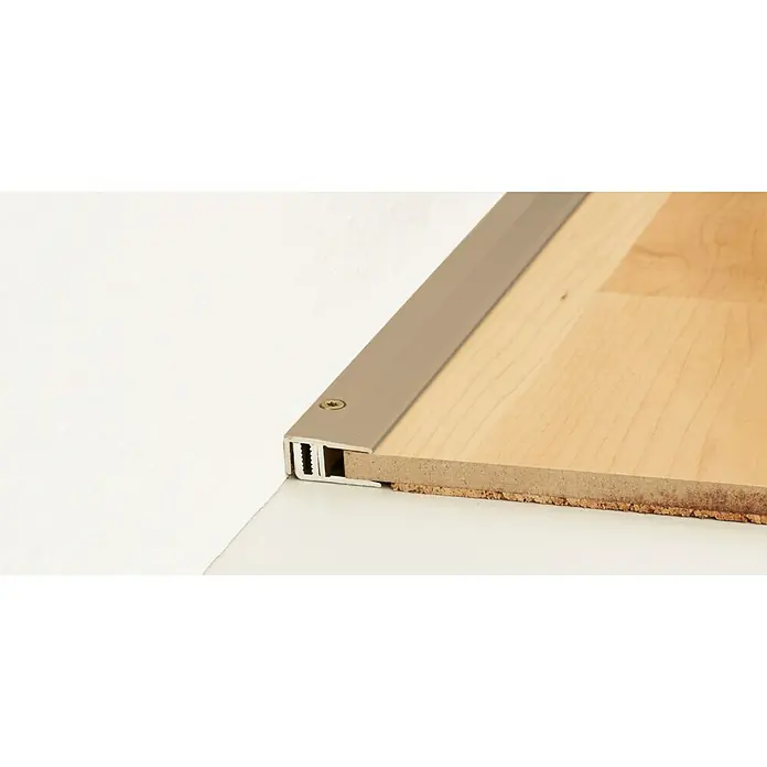LOGOCLIC Abschlussprofil 222 - Edelstahl matt, 2,7 m x 21 mm, Montageart: Schrauben - Nahaufnahme eines Bodenprofils aus Metall, das an einem Holzboden befestigt ist, und bietet einen sauberen Übergang zu einer weißen Oberfläche.