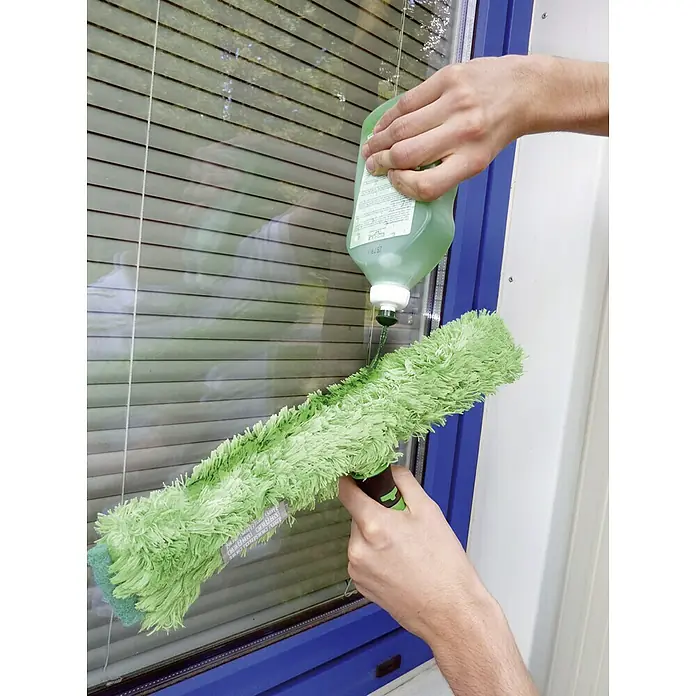 Unger Gel-Glasreiniger - 500 ml - Nahaufnahme einer Person, die ein Fenster mit einer grünen Bürste und Reinigungsflüssigkeit putzt.