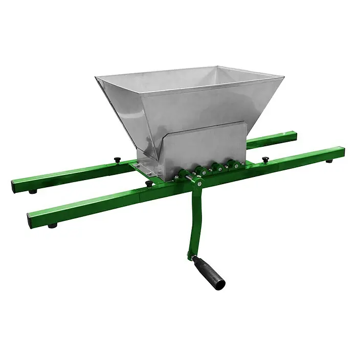 Güde Obstmühle OM 15 - Fassungsvermögen: 15 l - Nahaufnahme einer Obstmühle aus Edelstahl mit grünen Akzenten, die auf einer schwarzen Oberfläche steht und ihre robuste Bauweise zeigt.