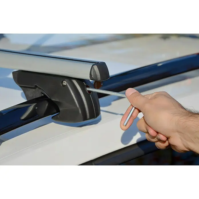 Fischer Dachträger TopLine XL - Traglast: 90 kg, L x B x H: 136,5 x 14,5 x 7,5 cm - Detailansicht eines Dachträgers, der mit einem Werkzeug am Auto befestigt wird. Praktisches Autozubehör für zusätzlichen Stauraum.