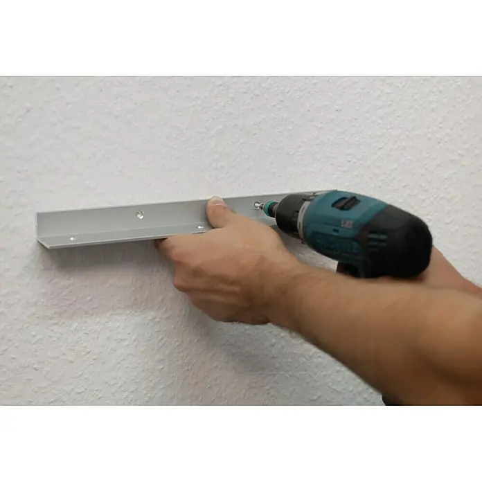 Easy Connect Montagewinkel - Passend für: Easy Connect Regalsystem, 3 Stk. - Eine Person befestigt mit einem Akkuschrauber eine Aluminiumleiste an einer Wand. Das Produkt ist eine silberne Aluminiumleiste für die Wandmontage.