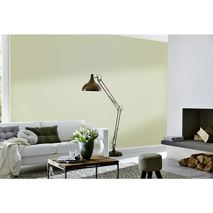 Knauf Feinspachtel Uniflott Finish - 20 kg, Gebrauchsfertig - Wohnzimmer mit einem weißen Sofa, einem Couchtisch und einer Stehlampe. Die Wand ist in einem hellen Grünton gestrichen.