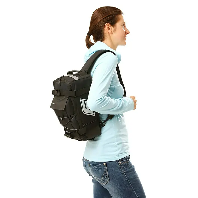 Fischer Gepäckträgertasche 2 in 1 - L x B x H: 18 x 16 x 32,5 cm - Eine Frau mit einem schwarzen Rucksack. Der Rucksack hat mehrere Fächer und Träger.