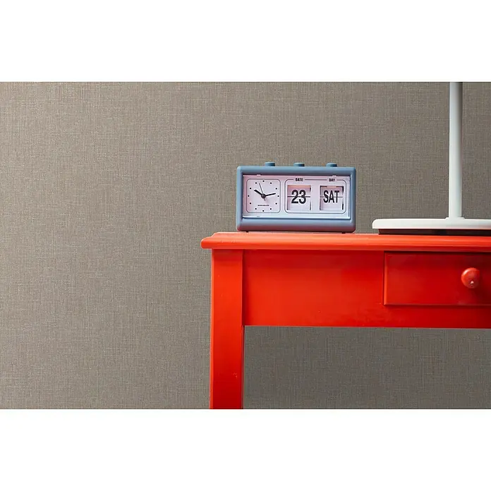 A.S. Création Metropolitan Stories Vliestapete Textiloptik - Pastellbraun, Uni, 10,05 x 0,53 m - Vintage-Tischuhr mit Kalenderfunktion auf einem roten Tisch. Das Zifferblatt zeigt die Zeit und das Datum "23 SAT" an.